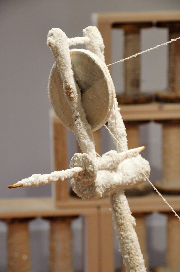 Spinning Jenny, salt and paper encrusted spinning wheel, 400 industrial bobbins filled with hand spun linen paper thread and encrusted with salt; hand built pine and hemlock shelves, 549 cm x 762 cm (room), 2013. Photo: Noelle Hamlyn