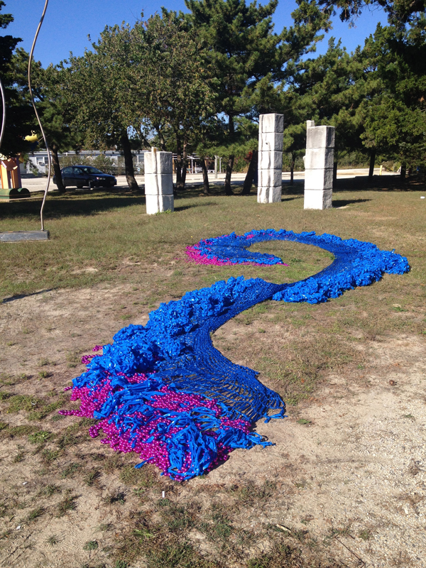 Swell, (outdoor installation view at The Long Beach Island Foundation of the Arts and Sciences sculpture garden, Loveladies, New Jersey) 2013. Crocheted fluorescent flagging tape and metallic plastic beads, dimensions variable.