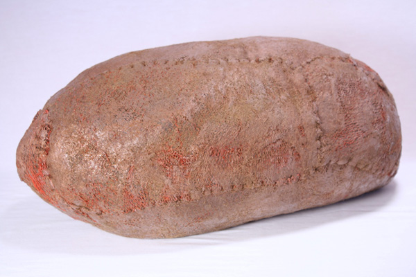 POD (Red net), wool, beeswax, thread, netting, pigment, recycled fill, 2013, 10" x 22" x 10", hand-felted, stitched, encaustic. Photo: Merce Mitchell