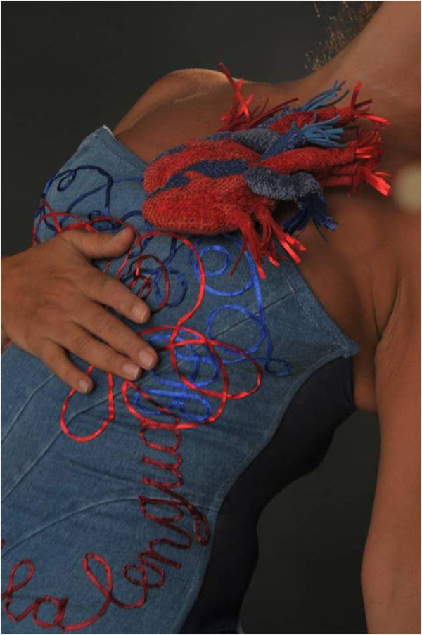 The corset MALINCHE POR LA LENGUA tells us about La Malinche, interpreter and lover of Hernán Cortés, the Spanish conqueror. Here, the difficult power balance is found thanks to the tongue, instrument for speech and lovemaking. The double heart indicates that she who loves passionately gets a further reward.
Materials: Appropriation of a cotton “habit trouvé”; pieces of recycled fabric; natural cotton filling; ribbon; magnetic clasps. Hand sewn.
Photo: Maurizio Donelli. Model: Estrella Benmaman.