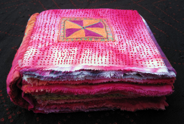 The Power of Red. Dyed fabric, hand stitch, a cloth book. Text by W Wordsworth 1807: "The world is too much with us, late and soon, getting an spending we lay waste our powers. Little we see in nature that is ours. We have given our hearts away, a sordid boon" 9" x 7" x 3" when closed. photo J Martin.