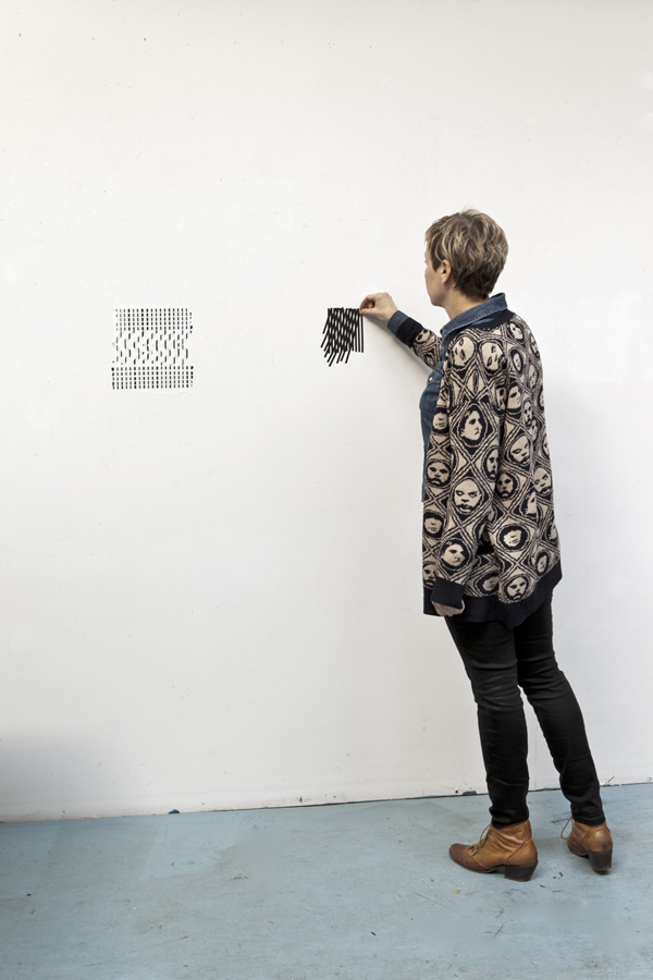 Joy Walker in the studio with tape drawings.