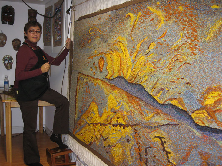 Ixchel Suarez working on the tapestry Impressions in the Savannah.