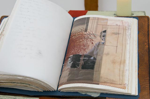 Detail: "Given and Received", Mixed media installation with handmade components, 81" x 20" x 25, 2010. Handmade/painted wooden book display, weaving, handmade collaged book with cross stitch binding and handsewn/dyed leather cover, digitally printed silk with free motion stitching, handmade beeswax candles.