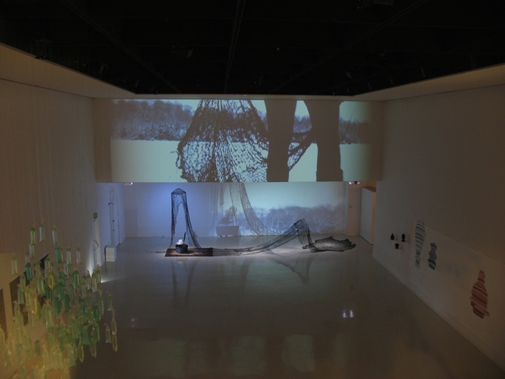 Unravel and Thaw (Penelope's Shroud), 2006, Burlap, multiple video projections, chair, rug, bucket, ice, Stony Brook, NY