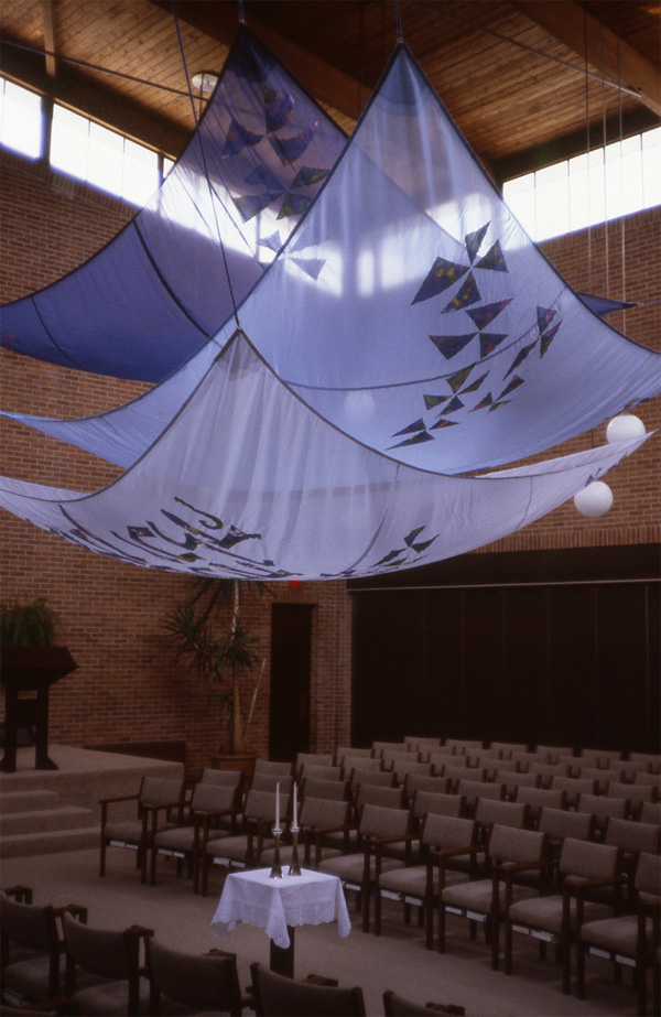 Wedding Canopy for Temple Emanu-El, Toronto ON, Polyester, silk, marine cables; hand-painting and machine appliqué, 3 triangles, each 18' on each side. Because the weddings at Temple Emanu-El take place in the midst of the congregation, not on the bimah, and because witnessing the vows is a necessary part of the marriage ceremony, I designed an expansive form that brings the congregation also under the chuppah.