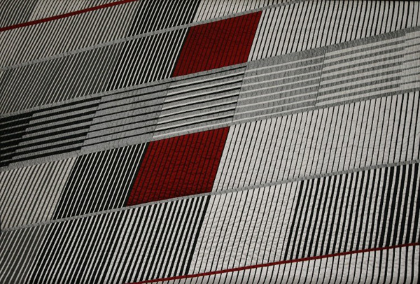 Rising (145 x 98 cm), Materials: silks

This quilt was accepted for the European Art Quilt IV exhibition and is especially made for it. The quilt has been shown in Lyon (F) during the Expo in June 2006, then in Mulhouse (F), Tilburg and Herning (DK). The starting point was a photograph of a building with awnings. I have copied the photo and the dimensions listed on a large sheet and then enlarged and copied. All slats needed to be separately calculated and drawn. Of course, I changed some things, like the vertical bar and the red squares. Because there are 4 parts in red this will draw your eye to the complete quilt.