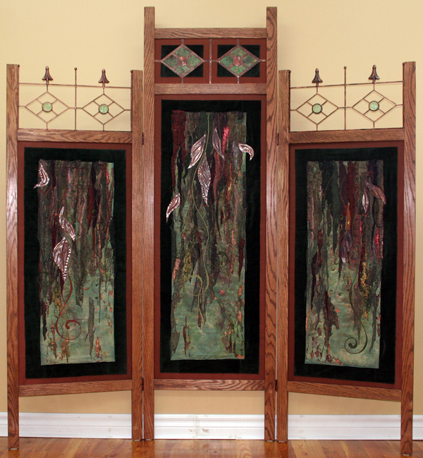 The Go Between, (70" (h) x 65" (w), 2010, Hand crafted oak framework, acts as a room divider; Folds into 3 panels, 21.5 inches wide, Hand painted silk; Commercial fabrics: synthetic satins and lining, lamé, chiffon, organza and tulle, metallic mesh; Copper; Painted Tyvek; Painted Heat Away stabilizer; Angelina; Glass beads; Chenille cord and Rayon heavy thread; Polyester, metallic and monofilament thread, Techniques: Collage; Copper embossing; Hand painting of silk; Thermo-fabrication with heat gun; Free motion embroidery and quilting; Sheer overlay and Encasement; Couching; Bobbin stitching; Hand beading.

Artist Statement:
As I sat at my sewing machine, layering stitched detail over the unique fusion of melted materials, I recognized the depth of story that always comes to life while I work on my art. This particular story is about connections between this world and the "other". As this 'divider' sits in my living room, it acts like an ancient interface - a portal, leading us into the depths and mysteries beyond. So, while it divides our living space, it also shifts us between our world and the next. Where does it take you?