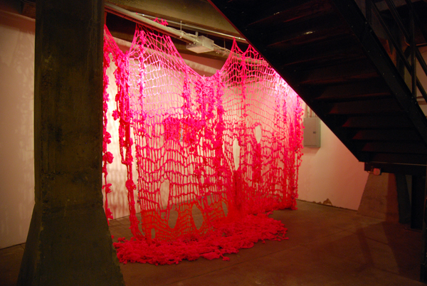 Behave (installation view at University of Delaware Gallery, Philadelphia, Pennsylvania) 2011. Crocheted and knitted fluorescent flagging tape, raw silk, ribbon, and children's barrettes, dimensions variable.