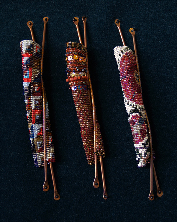 Women's Textiles series of Mezuzah bayit cases. Being a textile artist, it is natural to think of wrapping or enfolding. Just as a mother hugs her child, these mezuzah cases (attached to the doorpost of Jewish homes) embrace the klaf (parchment on which a specific Biblical passage is hand-scribed) figuratively and literally. The idea for this series comes from the experience of wrapping my tallit (prayer shawl) (slide A) around my daughter during prayer service, and the awareness that securing the klaf, teaching our children, and creating spiritual space are related commandments. Women everywhere create clothing and household textiles. This ongoing series is inspired by textiles that women make in various parts of the world.