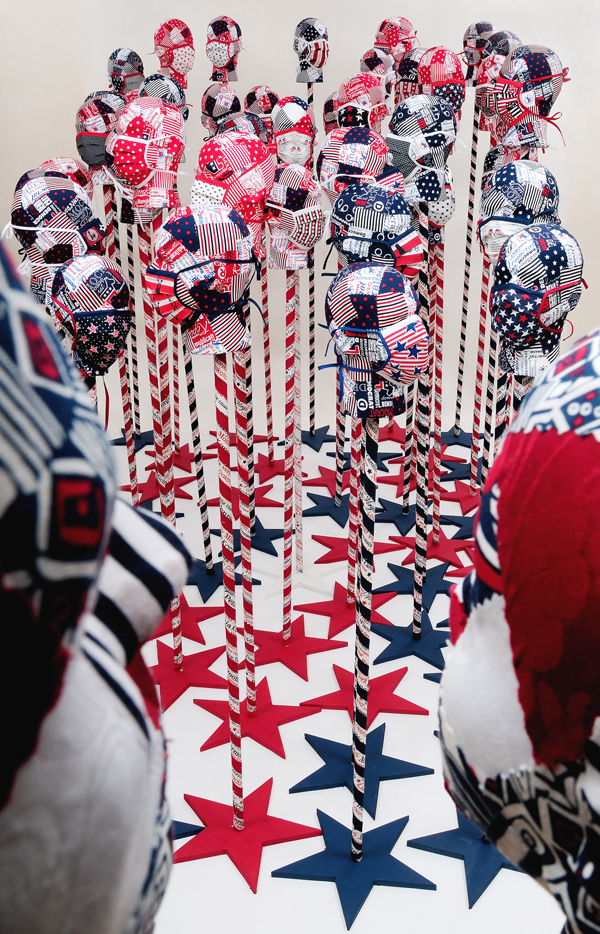 Stand! #8, Protest Series. Installation 52 stands/heads, Styrofoam, dowel rods, wood, commercial fabric, Decoupage, machine piecing, paint, 2011 Size Variable, Photor: Tom Fitzpatrick
 