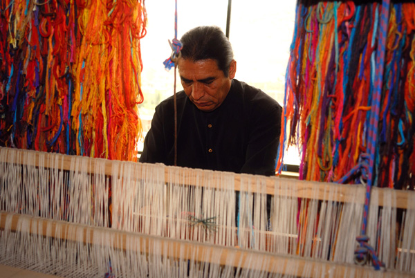 Maximo Laura weaving on the loom.
