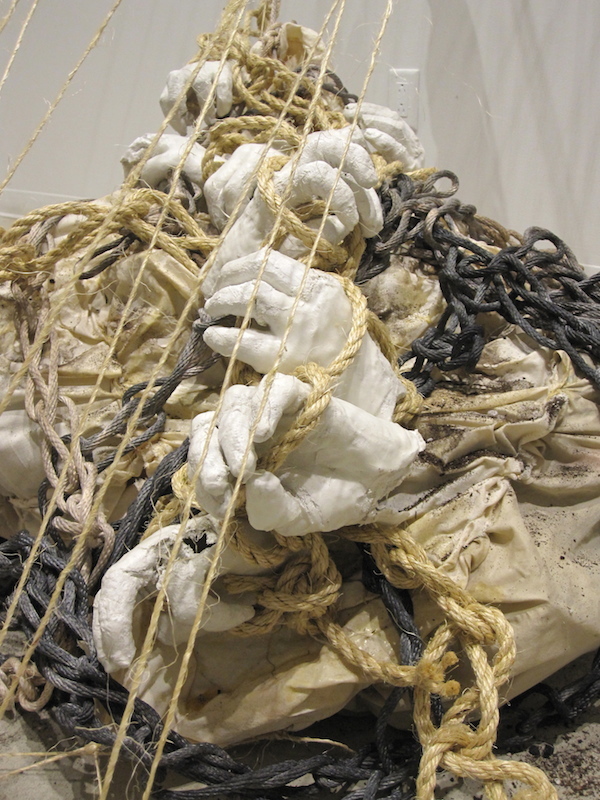 Of Synchronicity, detail, 2013, 9’H x 2’D x 5’W, plaster, wax, muslin, rubber latex, sisal, hand-dyed cotton rope, wood, pulley, dirt. Technique: Handmade, hand-dyed large-scale weaving loom using only a warp, plaster-cast hands, hand-sewn muslin. Photo: Mary Grisey. 