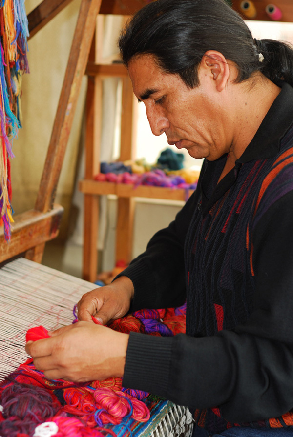 Maximo Laura weaving on the loom.