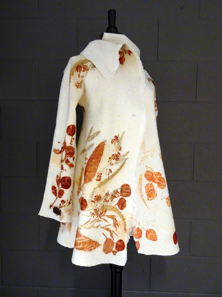 Vinitha Sara John: Botanically Inspired coat, April 2018, Size 8.
This seamless felted coat is made from superfine Italian merino and silk chiffon using the nuno felting technique. Then eucalyptus leaves are laid on the coat, tied into bundle and steamed. The heat helps the leaves release their pigments onto the felt. Finally, the coat has been finished with Kantha stitches using silk thread. 