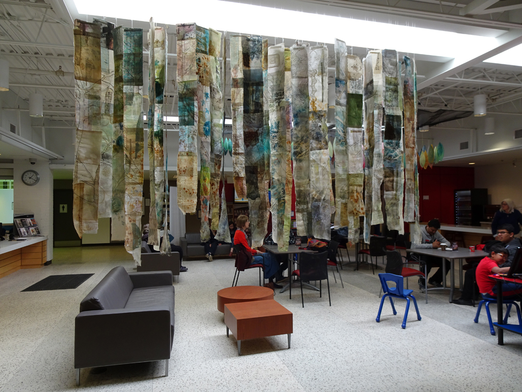 Cas Holmes: Trees, 2017, 20 pieces each 180H x 18-22 x 0.5D cm, cotton,  synthetics cloth and paper based found materials, printed with disperse dyes and acrylic paints, machine and hand stitched.