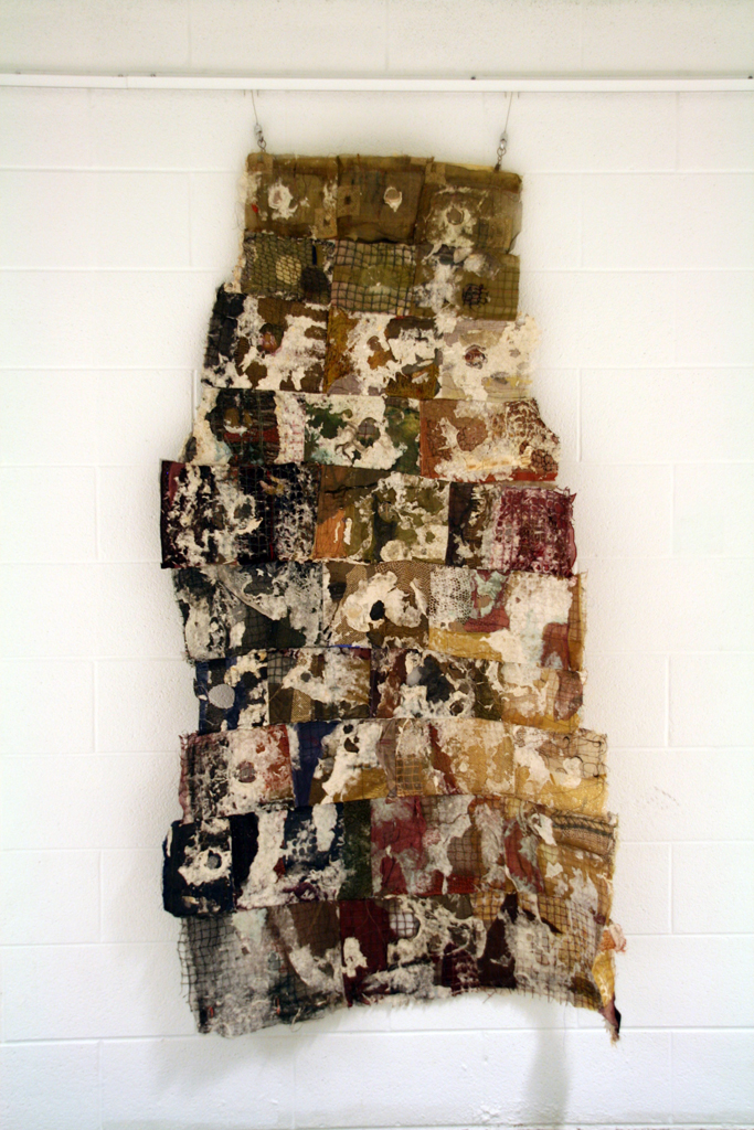 Cast Mountain Kesa (priest robe), 2014-5, 70 x 36 x 18, Pieced, quilted various fabrics; screen, mesh, net, sheer metallics, silks, synthetics, loose recycled fibers. Abaca paper pulp. Machine sewn and quilted randomly, holes cut in layers. Dipped and cast in paper pulp which was worked into the fabric and pasted to suggest Buddhist scriptures.