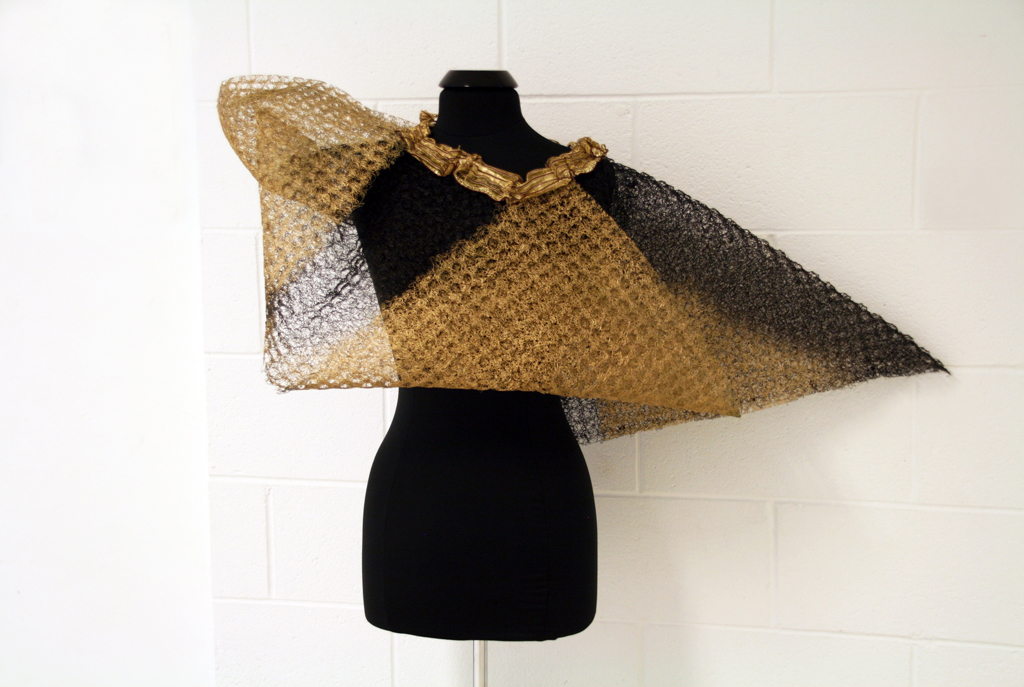 Folded Gold, 2015, 108H x 48W x 40D cm, plastic mesh salvaged from roofing industry, salvaged ribbon, aerosol paints. Technique: Folding, cutting, stenciling, joined with cable ties.  