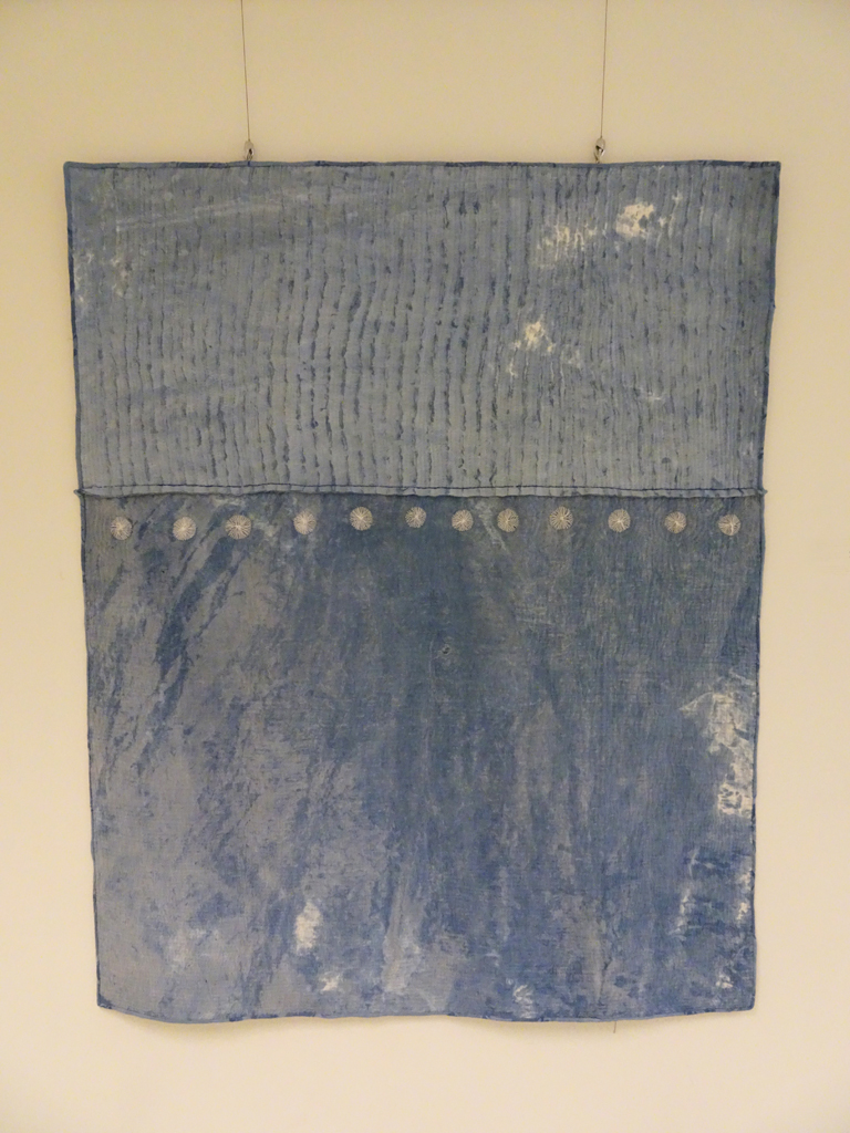 Lake, 2014, 168 cm h x 133 cm w, re-purposed linen damask, hemp-silk fabric, indigo dye, cotton threads, bamboo batt.  Paste resist, hand embroidery, hand quilting.  Hand stitched quilt. 