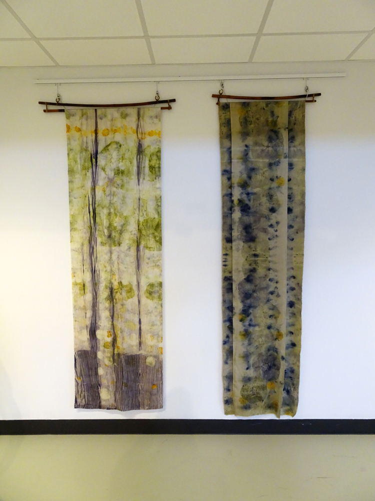 Left: Silken Hibiscus, 2015, 78” H x 24” W x ¼” D, 100% silk. Technique: Ecoprinted with plants from my garden using their natural dyes and shibori technique with logwood natural dye. 
Right: Hibiscus Homily, June 2014, 81” H x 23” W x ¼” D, wool/rayon/silk blend. Technique: Ecoprinted with plants from my garden using their natural dyes. 