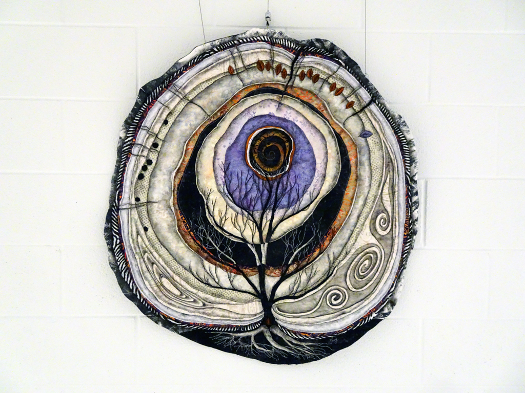 Lorraine Roy: Call of the Heart,  2018   36x36”. Cotton and synthetic fabrics, cotton batting. Techniques: machine raw edge machine, machine embroidery and quilting, small amount of acrylic paint.