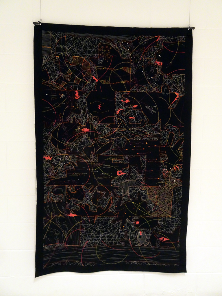 Paula Kovarik: Disruptors, 2017, 64Hx40W, cotton whole cloth fabric printed with a steamroller on a hand carved 8’x4’ wood cut in black ink. Stitched and quilted with cotton batting and thread.