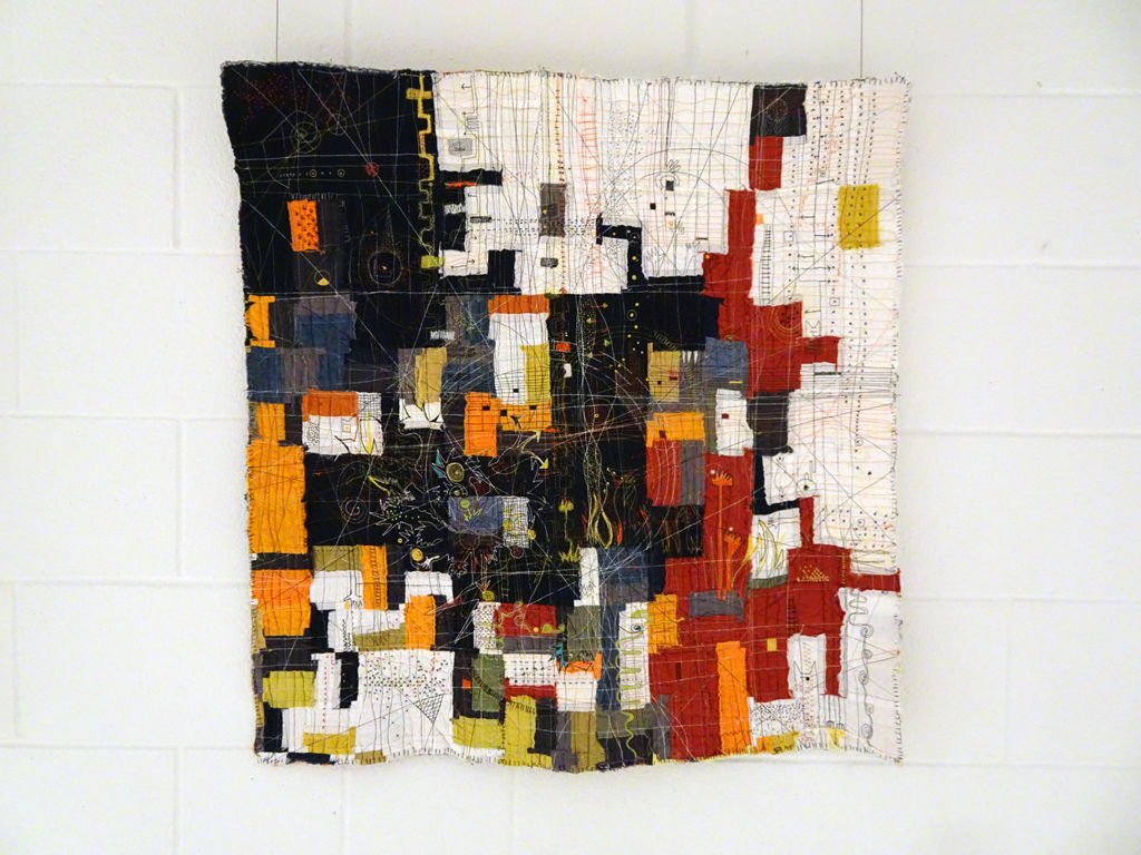 Paula Kovarik: Focus on Something Else, 2017, 32Hx32W, cotton fabrics assembled as a collage onto drapery lining, cotton batting, hand and machine stitched with cotton threads.