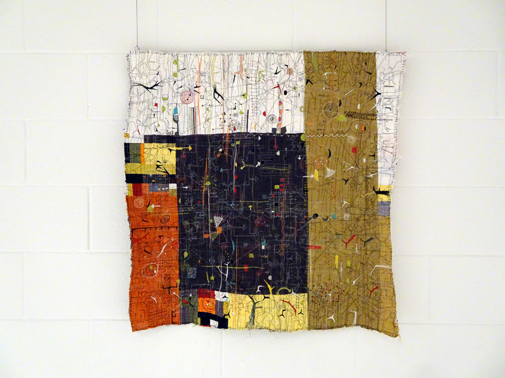 Paula Kovarik: Chaos Ensues, 2017, 32Hx32W, cotton fabrics collaged and quilted with cotton batting, free-motion stitching by machine. 