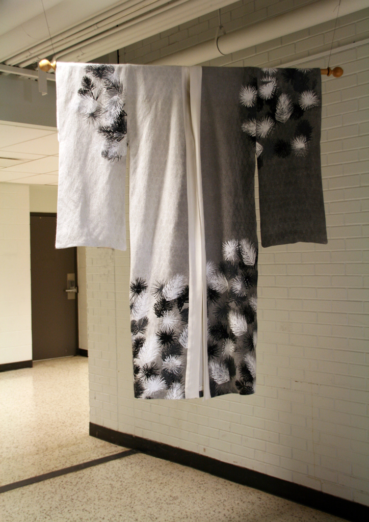 White Pine: 2016, 60H x 54W  Handwoven silk warp and paper yarn weft.  This is a 16shaft 
pattern.  The kimono was inspired by a Japanese kimono  “Shoin” created by Yuri Keiko. The Cloth was painted using a pigment system then details were stenciled in using textile paints. Photo: Pete Paterson.