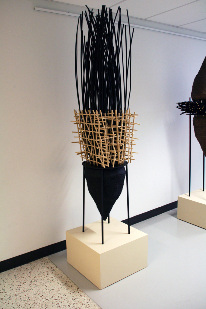 Eva Ennist: NESTING: Entangled, 2017/18, 304.8 cm x 54.25cm x 54.25cm, reed, cast resin, wood, steel, paint. Techniques: weaving, coiling, casting. Mounted on wood base.