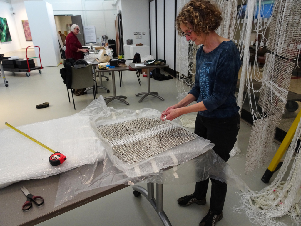 Artist: Elaine Whittaker installing her work, Tethered, World of Threads Festival 2016.