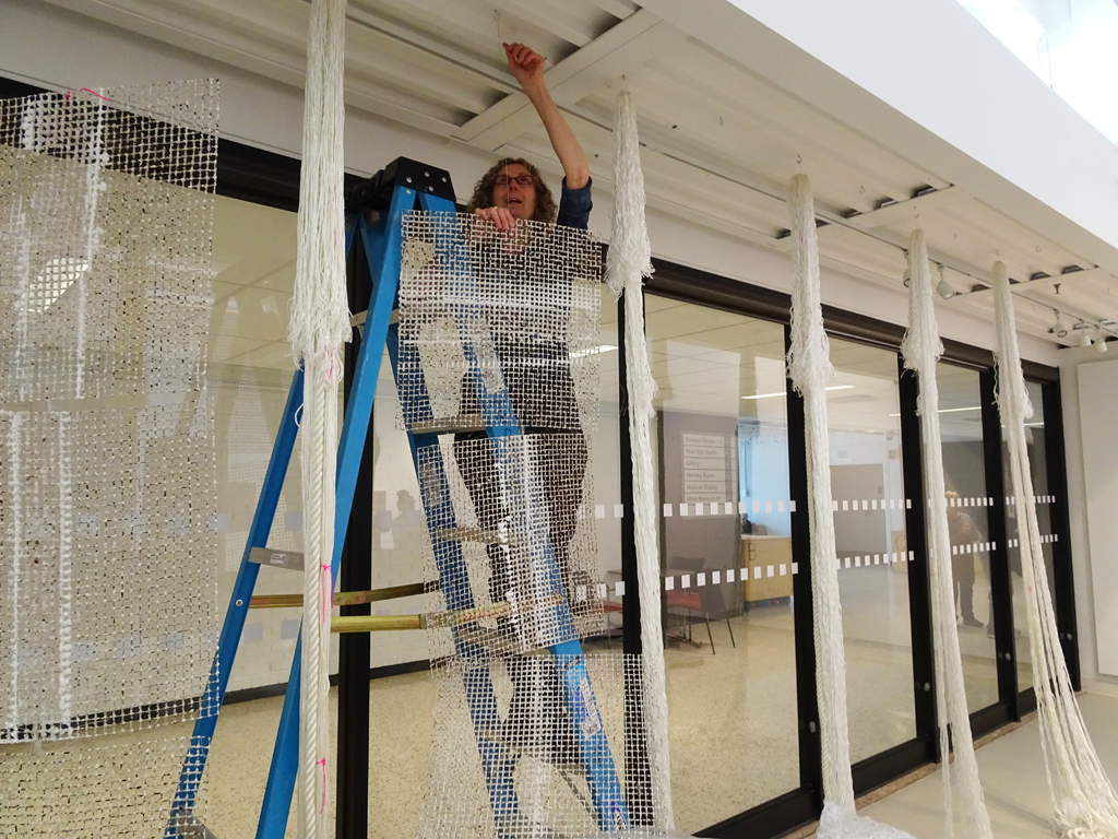 Artist: Elaine Whittaker installing her work, Tethered, World of Threads Festival 2016.
