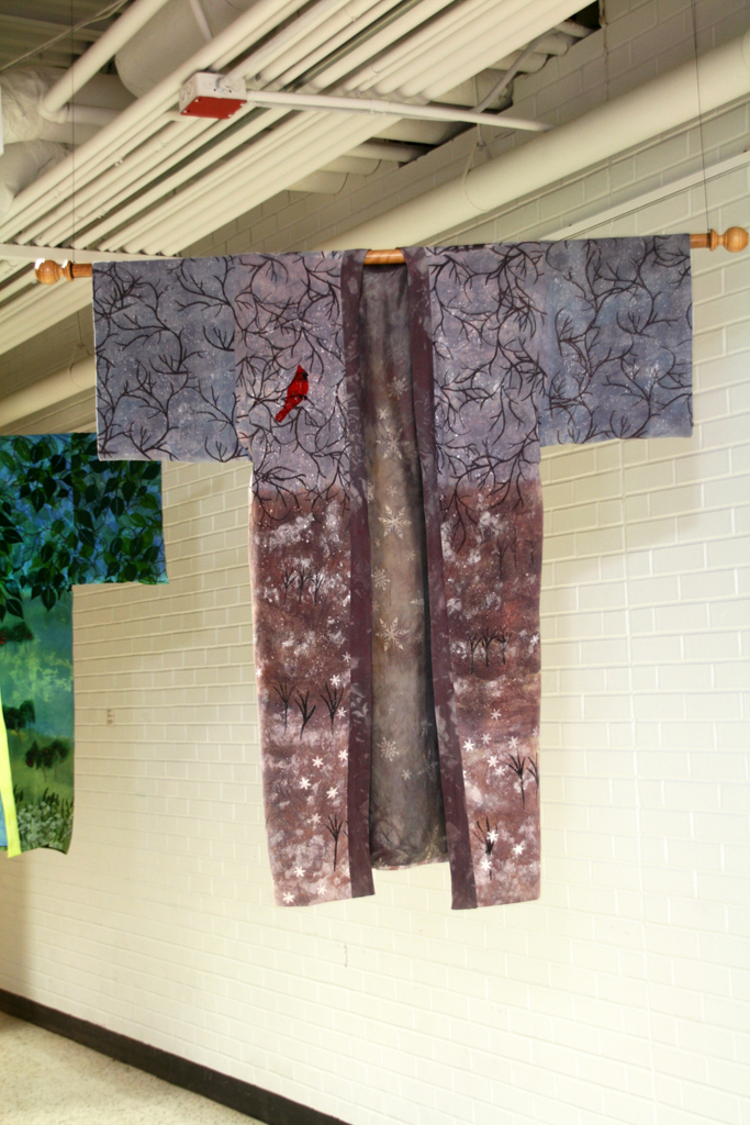 Winter Snow, 2015, 60H x 52W  Handwoven 2/20’s silk yarn warp and weft sett, 30 threads per inch. Stenciled using the paper lamination from Reflections then overdyed, discharged, then overdyed again.  Details were stenciled and handpainted in using textile paints and thickened dyes. Lining is commercial silk that has been dyed and discharged. Photo: Pete Paterson