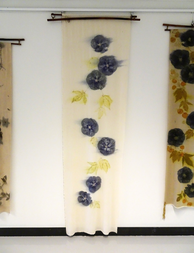 Linda Kollofski: Hibiscus 7, 2017, 90H x 27W x .5D inches, woven silk noil and flowers/leaves. Technique: Ecoprinted with plants from my garden using their natural dyes. Hung on bamboo hanger: 35W x 3H.