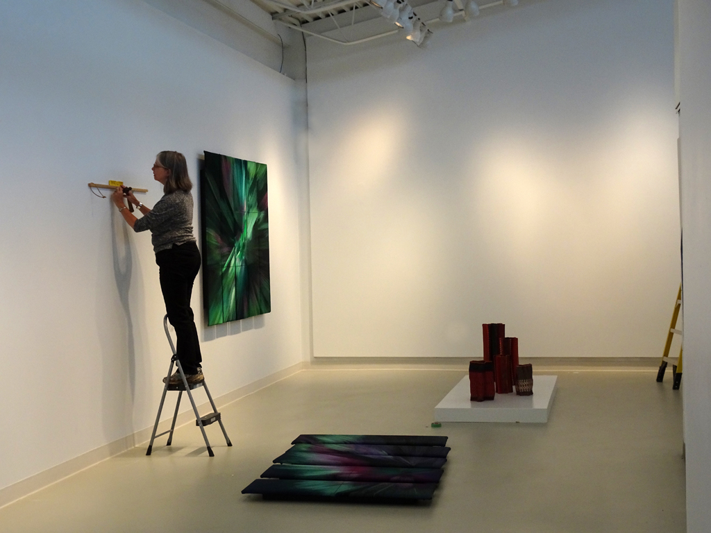 Festival Installer: Ruth installing artwork for the Cosmic Geometry exhibition, World of Threads Festival 2016.