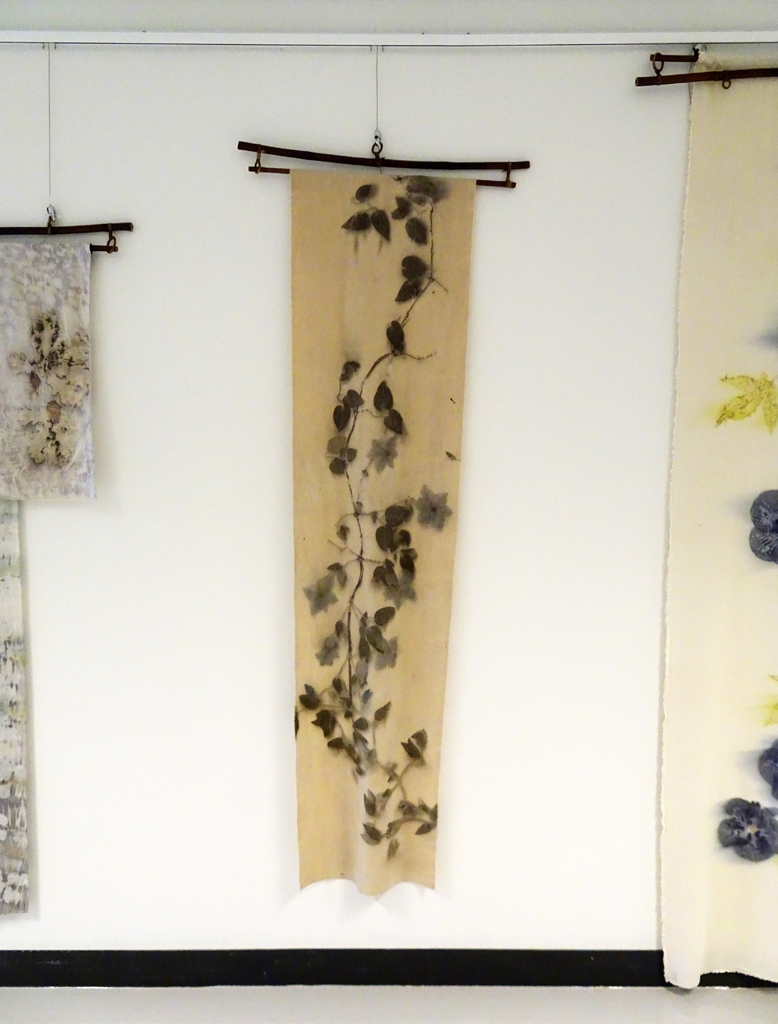 Linda Kollofski: Clematis Vine, 2017, 71H x 17.5W x .5D inches, woven silk noil and flowers/leaves. Technique: Ecoprinted with plants from my garden using their natural dyes. Hung on bamboo hanger: 27W x 3H.
