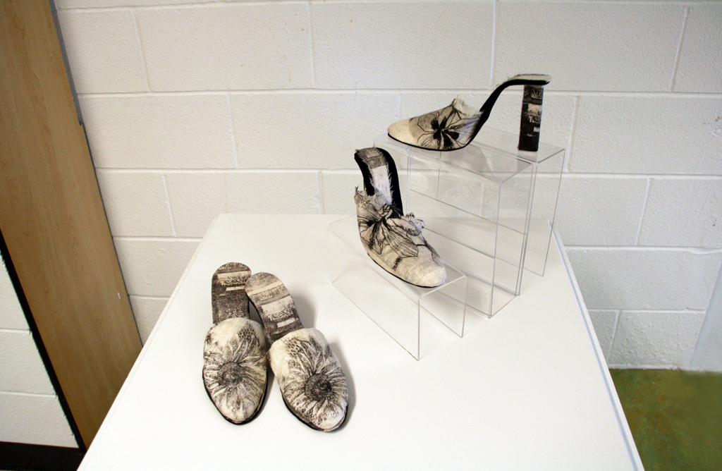 Favourd Footsteps, 2016, Thai silk, etching ink image, 2ply Thai silk covering mat board insoles Technique:  Hand drawn image transferred onto etching plate by solar rays. This etching pate is inked and the image transferred to the silk when passed 	through a manual press.