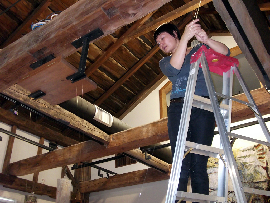 Emily Jan installing her artwork, De rerum natura, World of Threads Festival 2012.