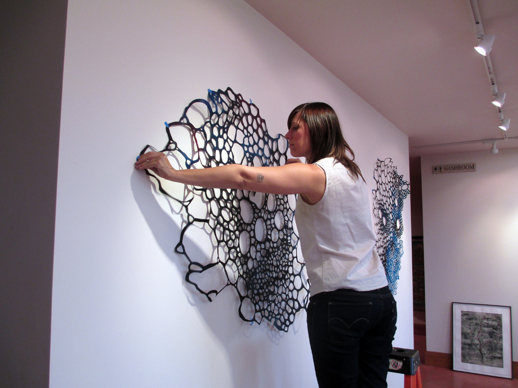 Lizz Aston installing her artwork, De rerum natura, World of Threads Festival 2012.