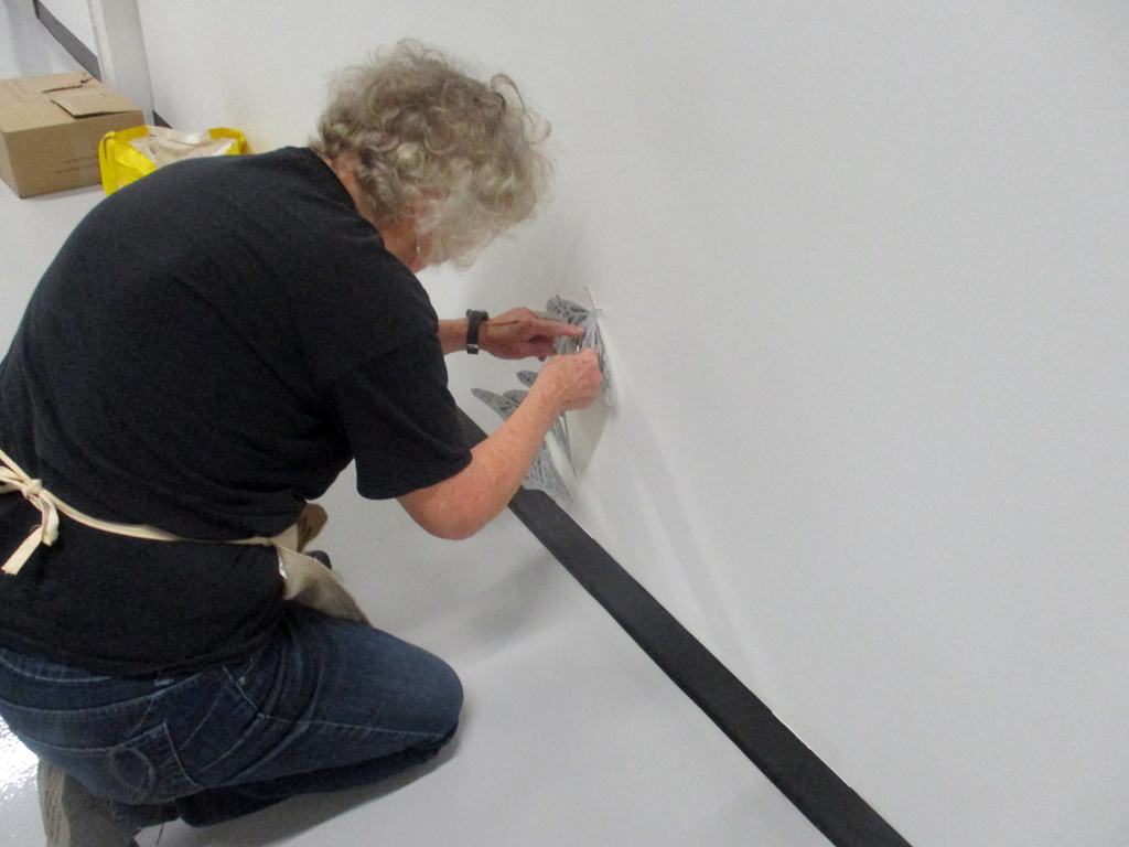 Artist: Lorna Livey installing her Safety in Number installation, World of Threads Festival 2023.
