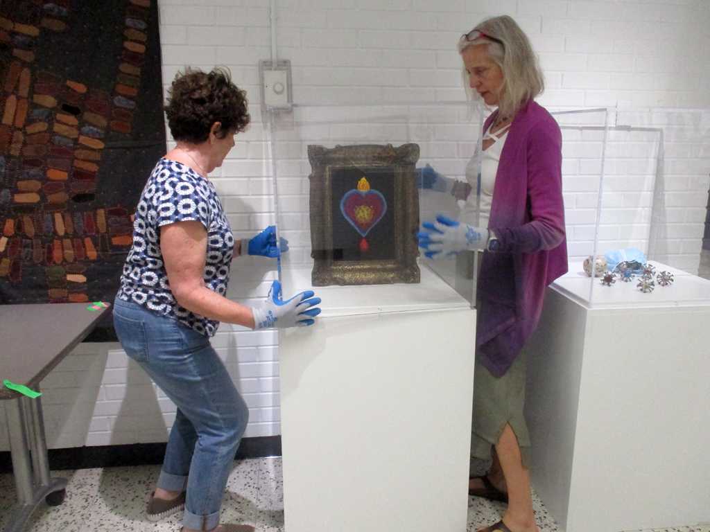 Festival installers, Carol and Carol, installing work in the Covid Forever exhibition, World of Threads Festival.