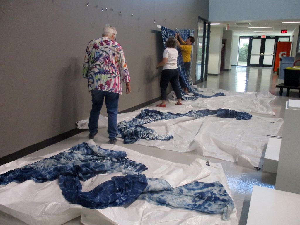 Laying out artwork ready to install, World of Threads Festival 2023-24.