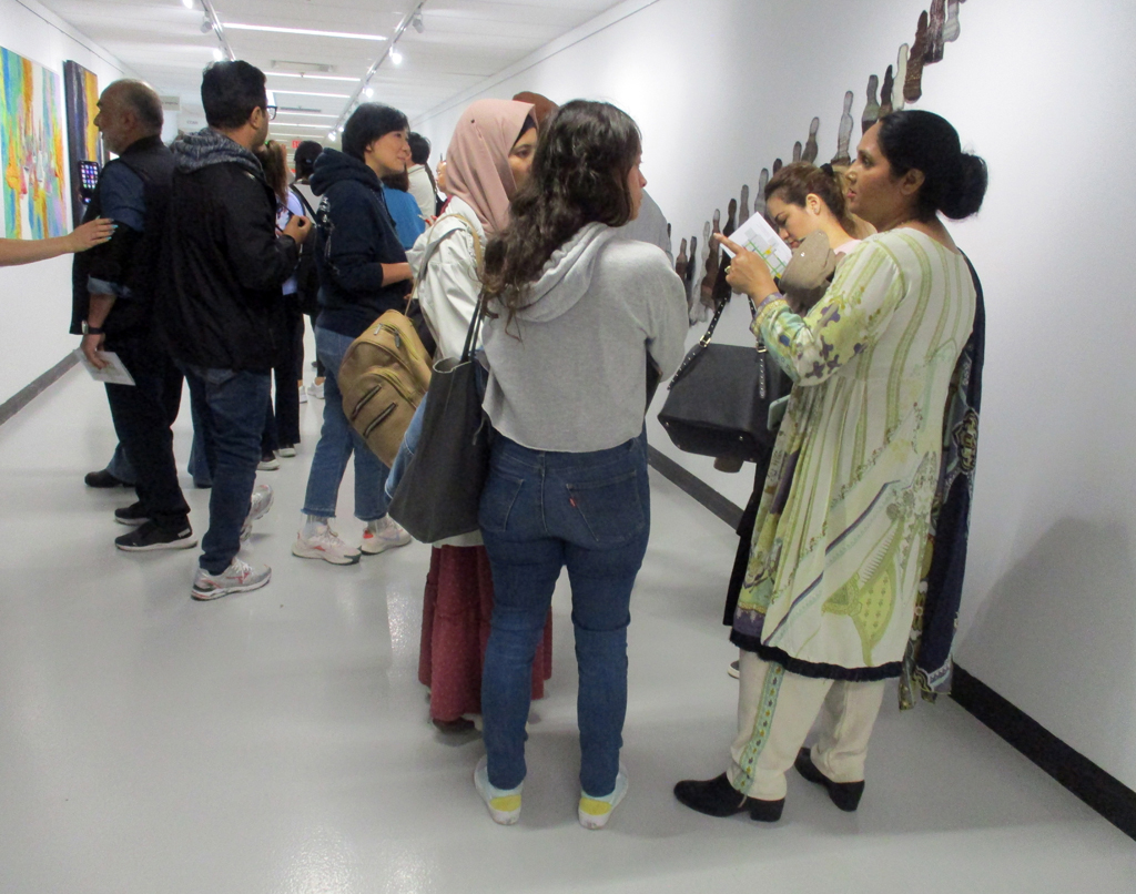 Visitors looking at The Ovine Conspiracy installation, World of Threads Festival 2023-24..