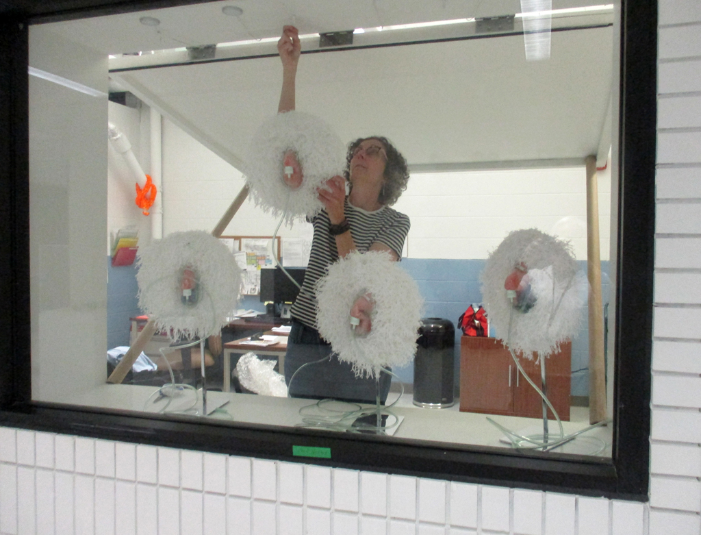 Elaine Whittaker installing her work in the Covid Forever exhibition, World of Threads Festival.