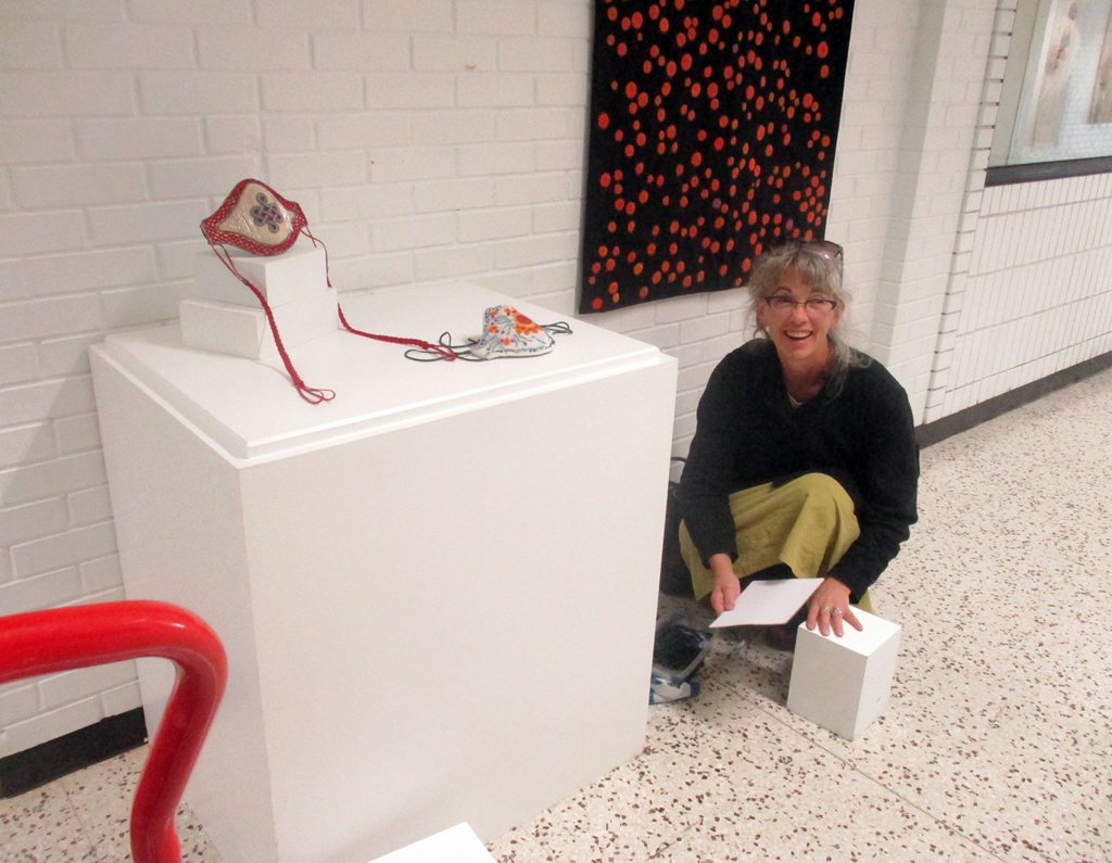 Tracy Gorman installing her work in the Covid Forever exhibition, World of Threads Festival 2023-24.
