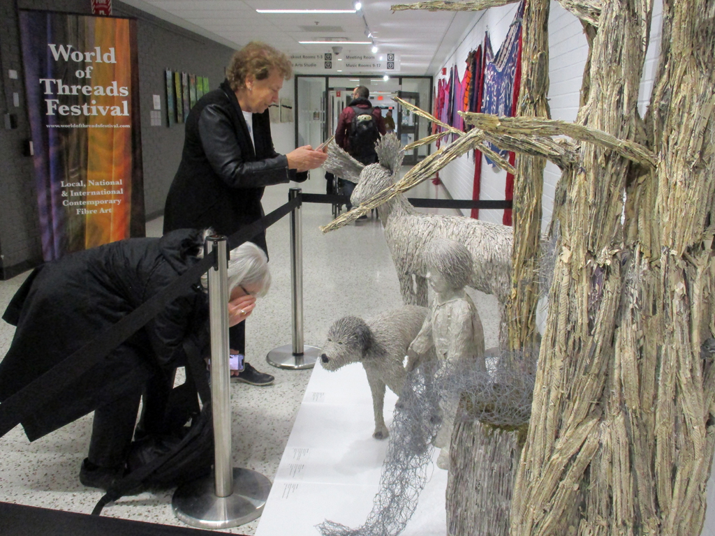 Visitors looking at the Cycle of Life installation, World of Threads Festival 2023-24.