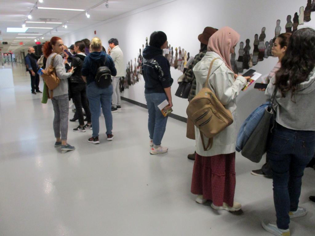 Visitors looking at The Ovine Conspiracy installation, World of Threads Festival 2023-24.