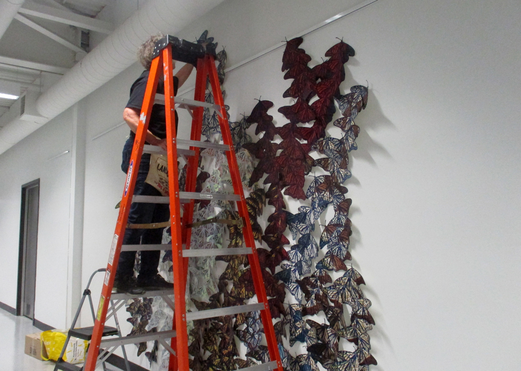 Artist: Lorna Livey installing her Safety in Number installation, World of Threads Festival 2023.