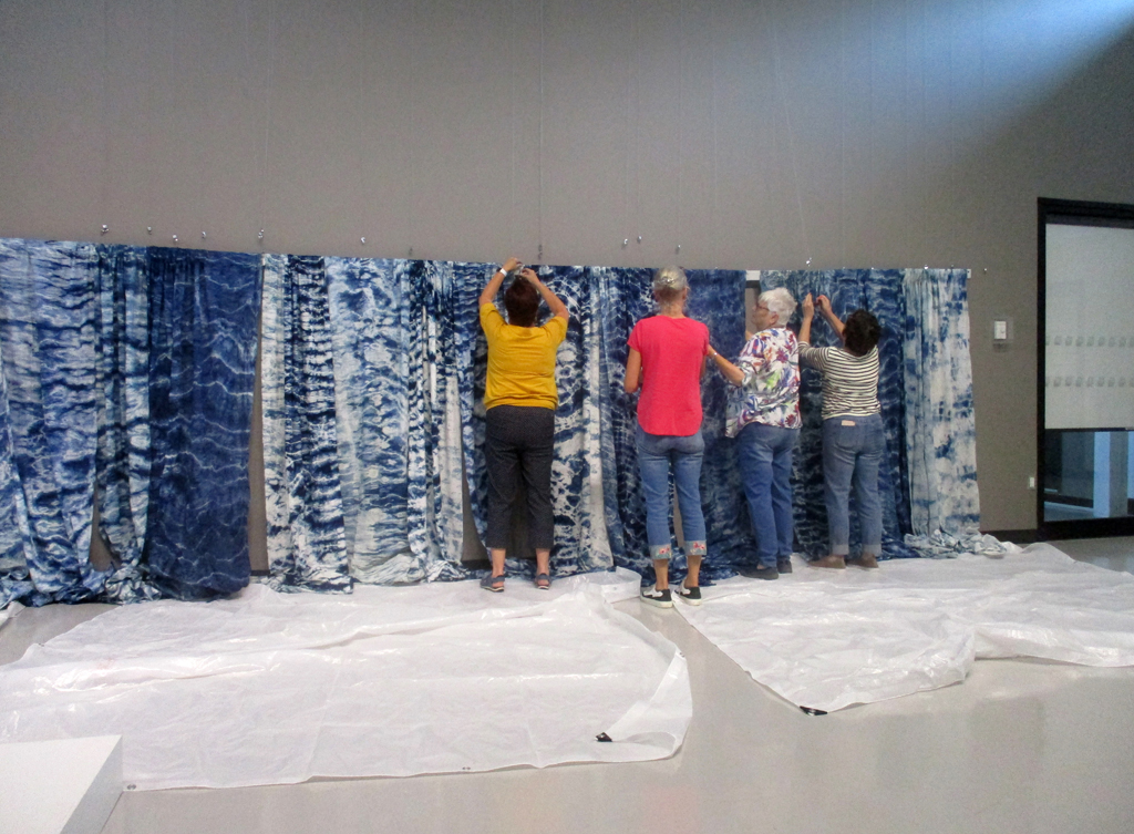 Festival Installers: Freda, Caren, Chris and Carol, installing Pacific Ocean, World of Threads Festival 2023-24.
