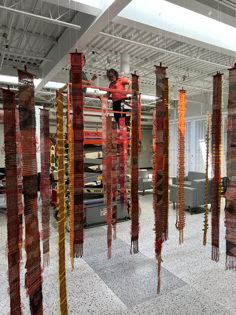 Festival installer: Heidi working on the Diaphanous installation, World of Threads Festival 2023-24.